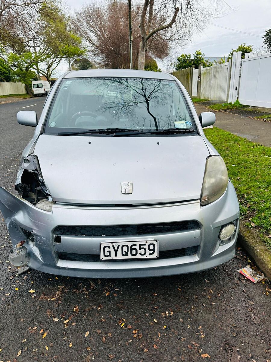 Damaged hatchback parked on a South Auckland street ready to be sold fast for cash
