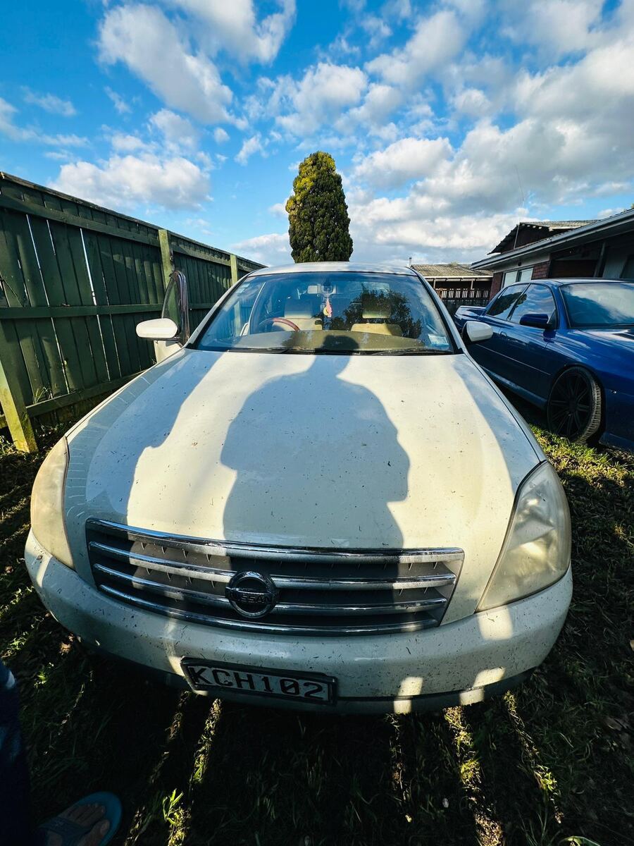 Old Nissan Teana parked on a South Auckland driveway ready for free old car removal
