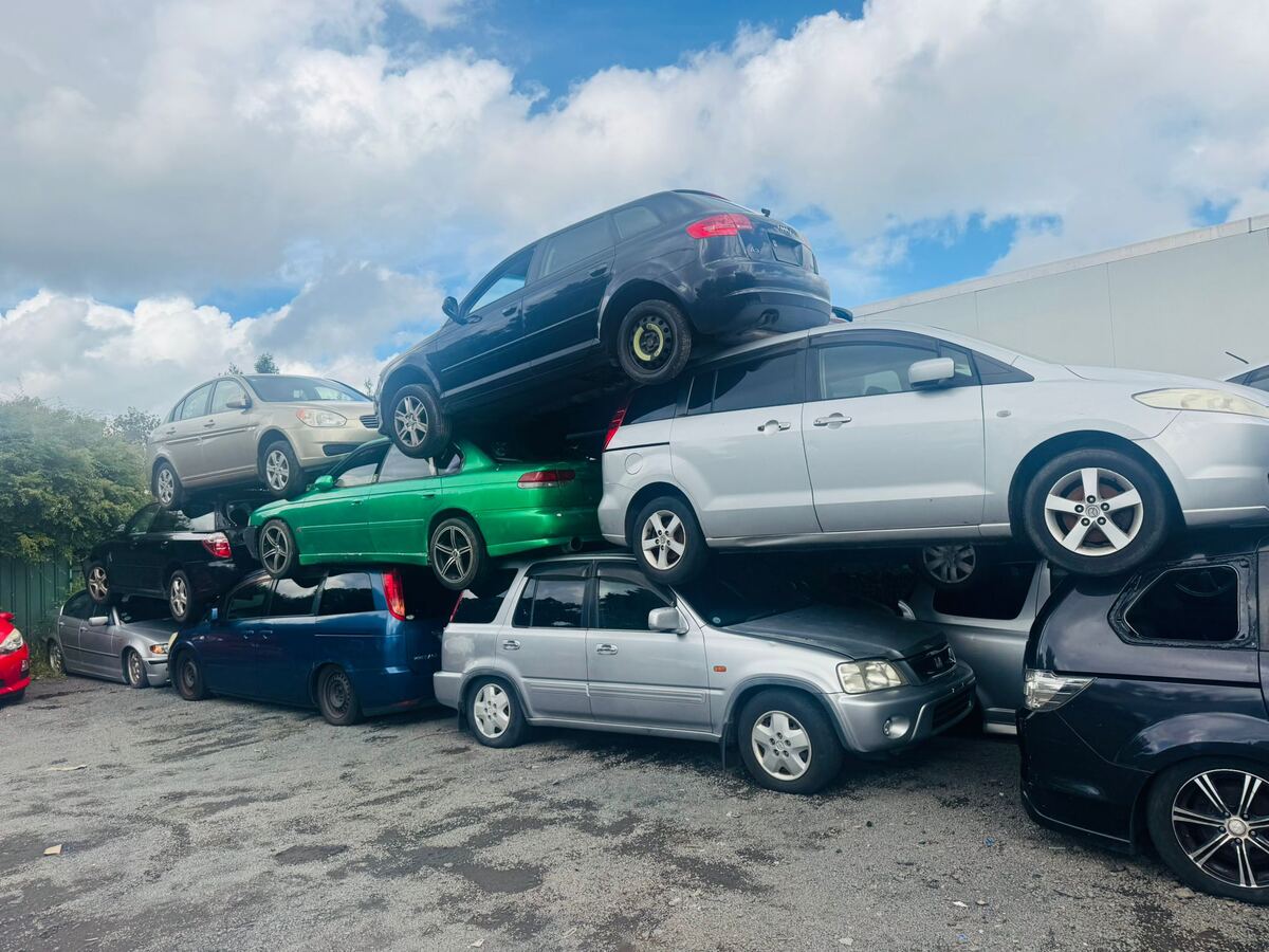 Scrap cars stacked at a wrecking yard after being bought from South Auckland owners