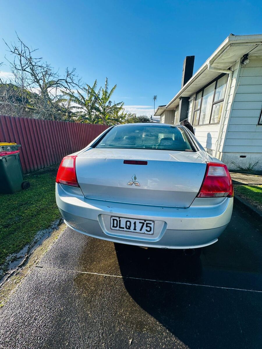 Unwanted Mitsubishi sedan sitting on a South Auckland driveway awaiting free removal