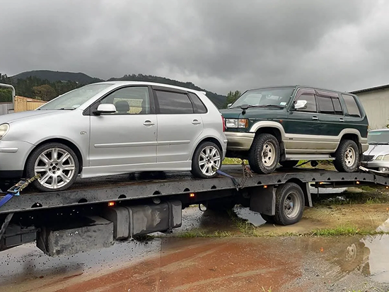 Tow truck carrying two scrap cars in South Auckland
